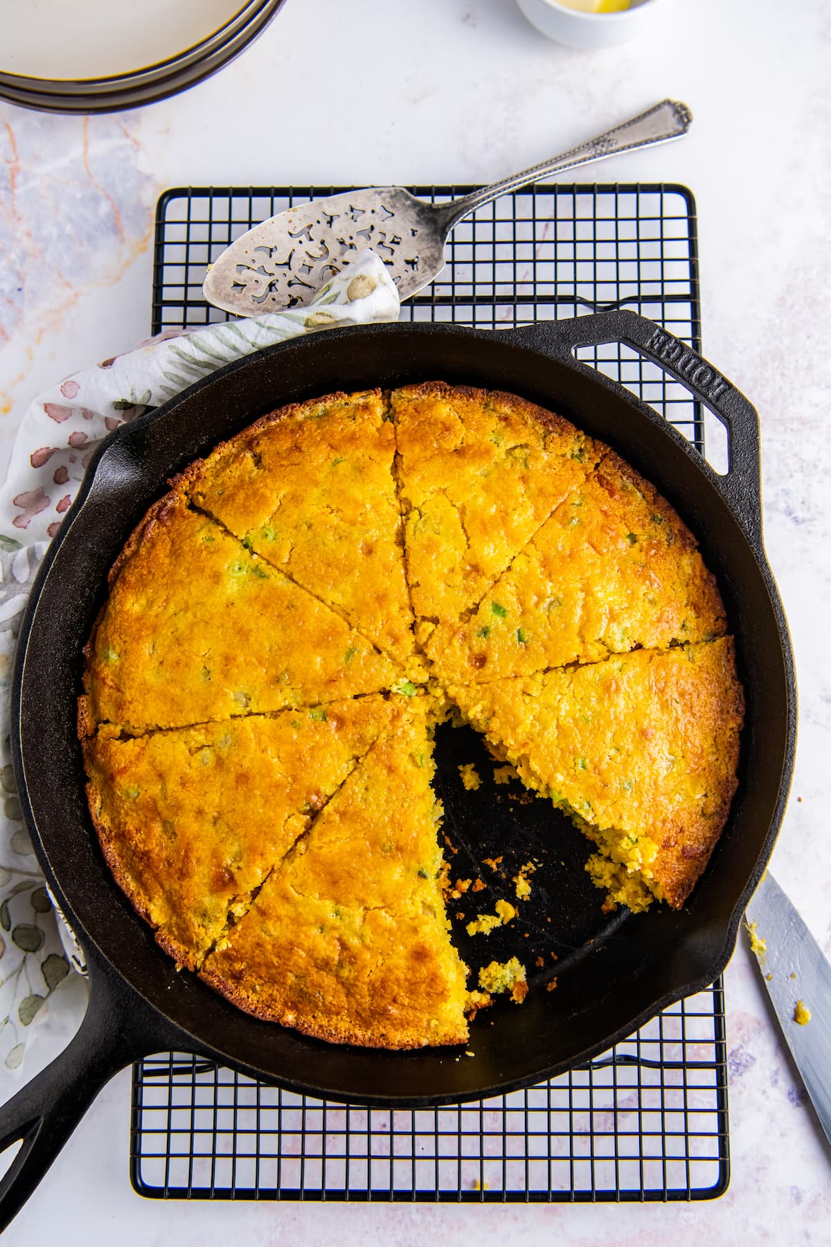 cornbread in a skillet that has been cut into slices and one has been removed