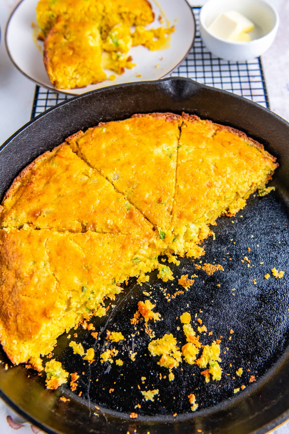 a skillet with sliced cornbread and half of the cornbread has been removed