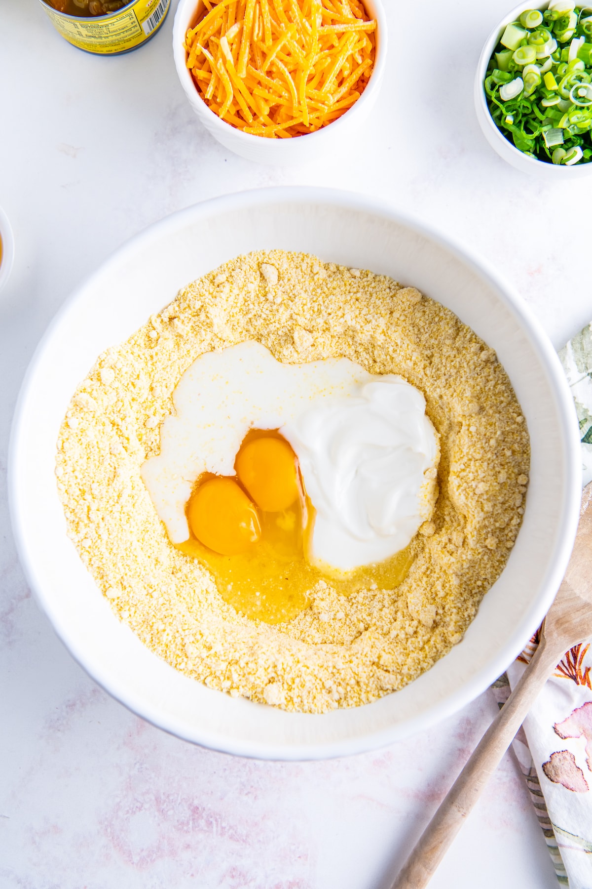 jiffy cornbread mix in a bowl with eggs and sour cream
