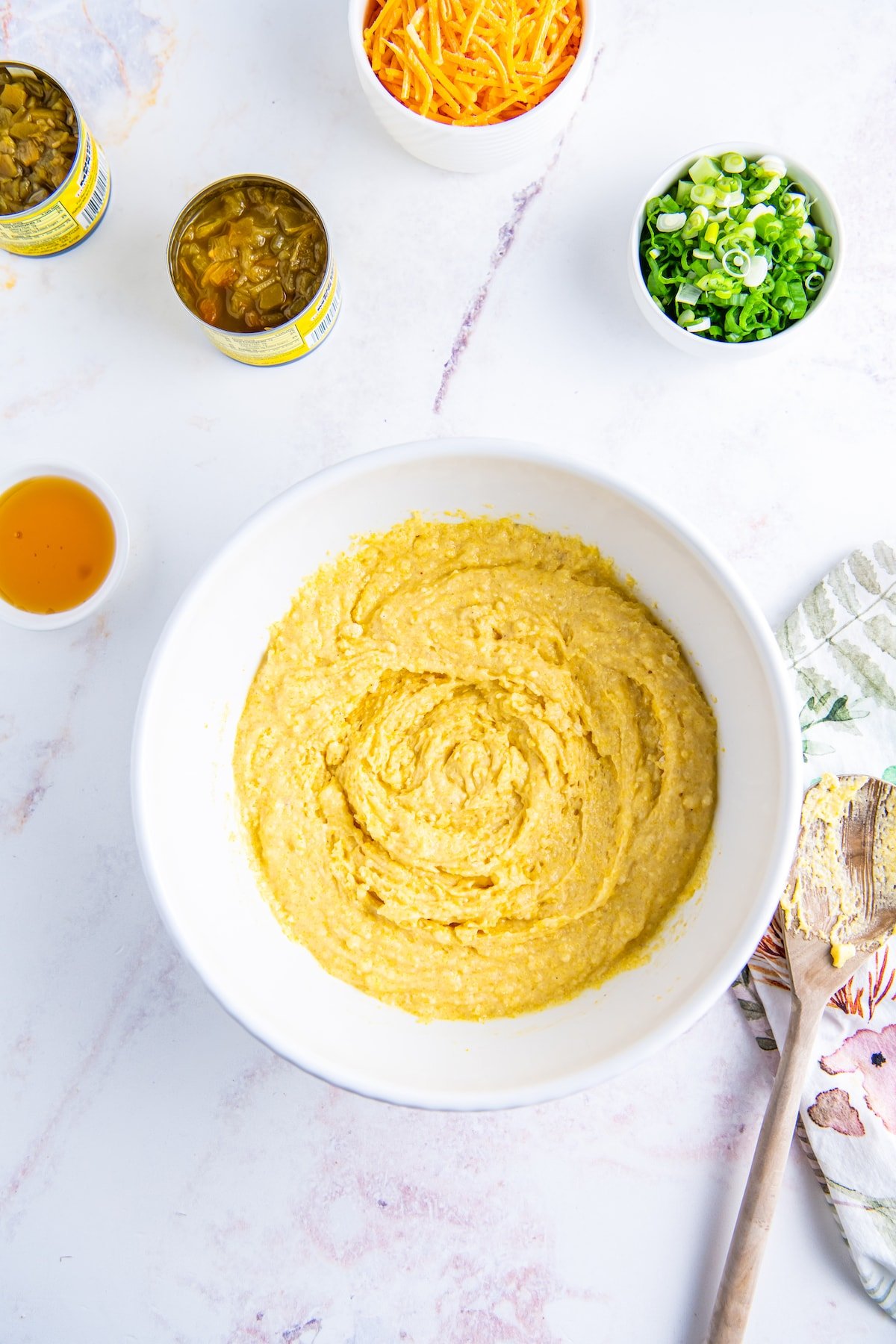 cornbread batter in a white bowl on a marble countertop