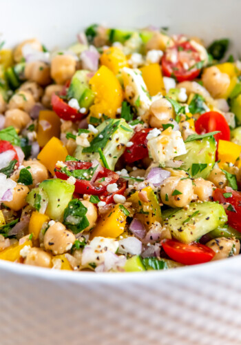 a bowl of chickpea salad with vegetables and herbs