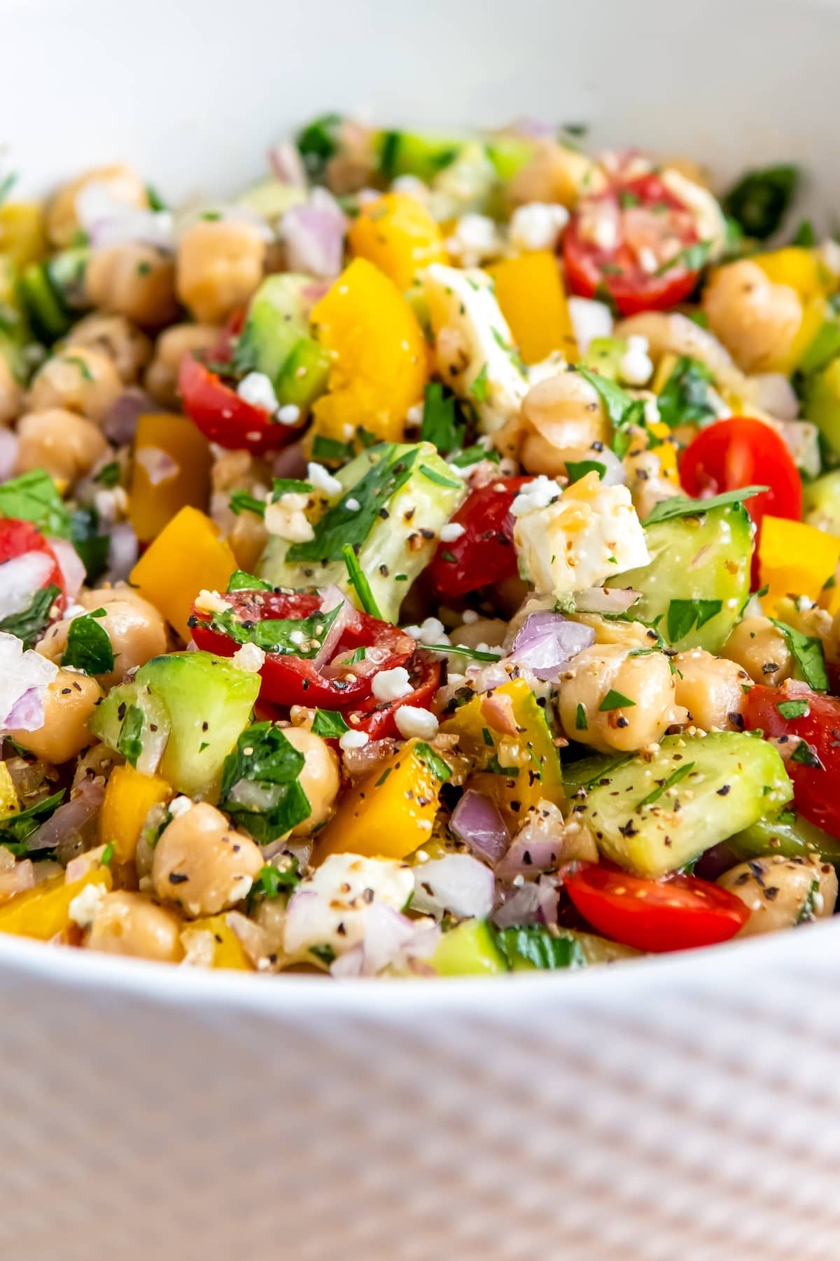 a bowl of chickpea salad with vegetables and herbs