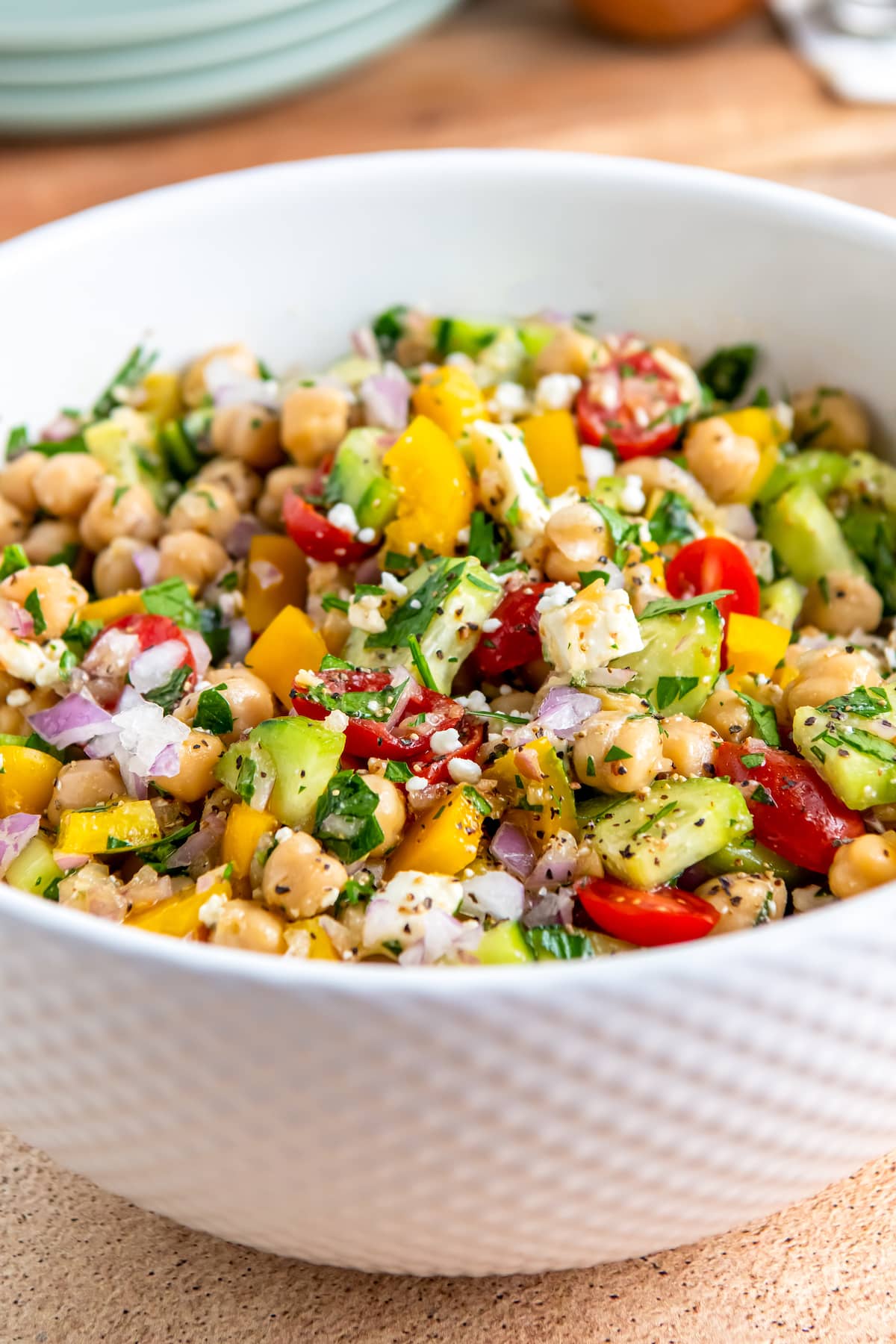 a bowl of chickpea salad with vegetables and herbs