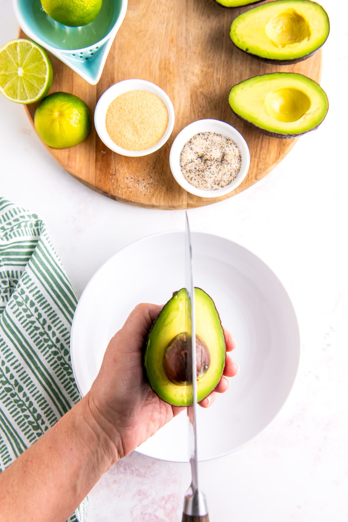 using a chef knife to remove the pit from an avocado