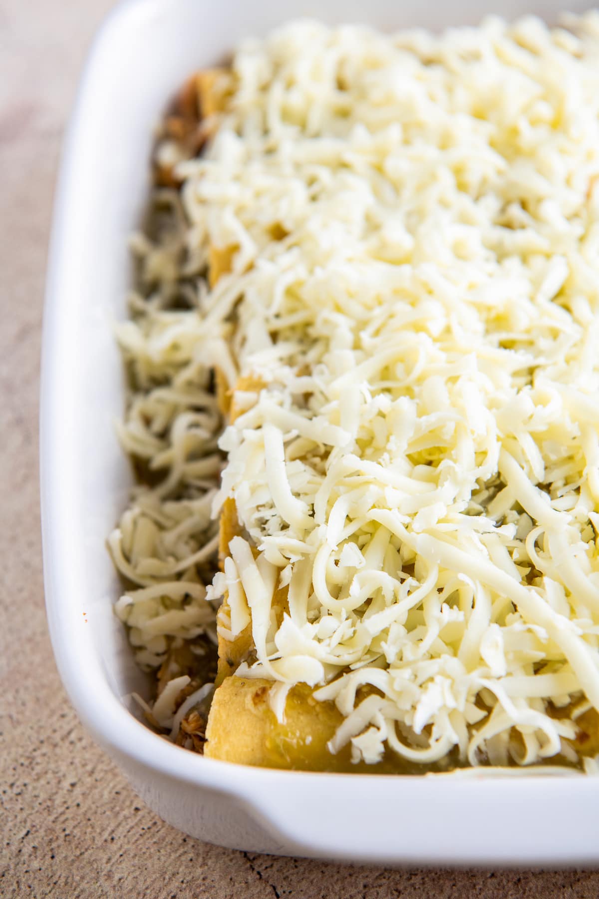 a casserole with enchiladas and shredded cheese on top