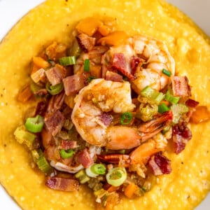 a bowl of shrimp and grits on a green and white napkin