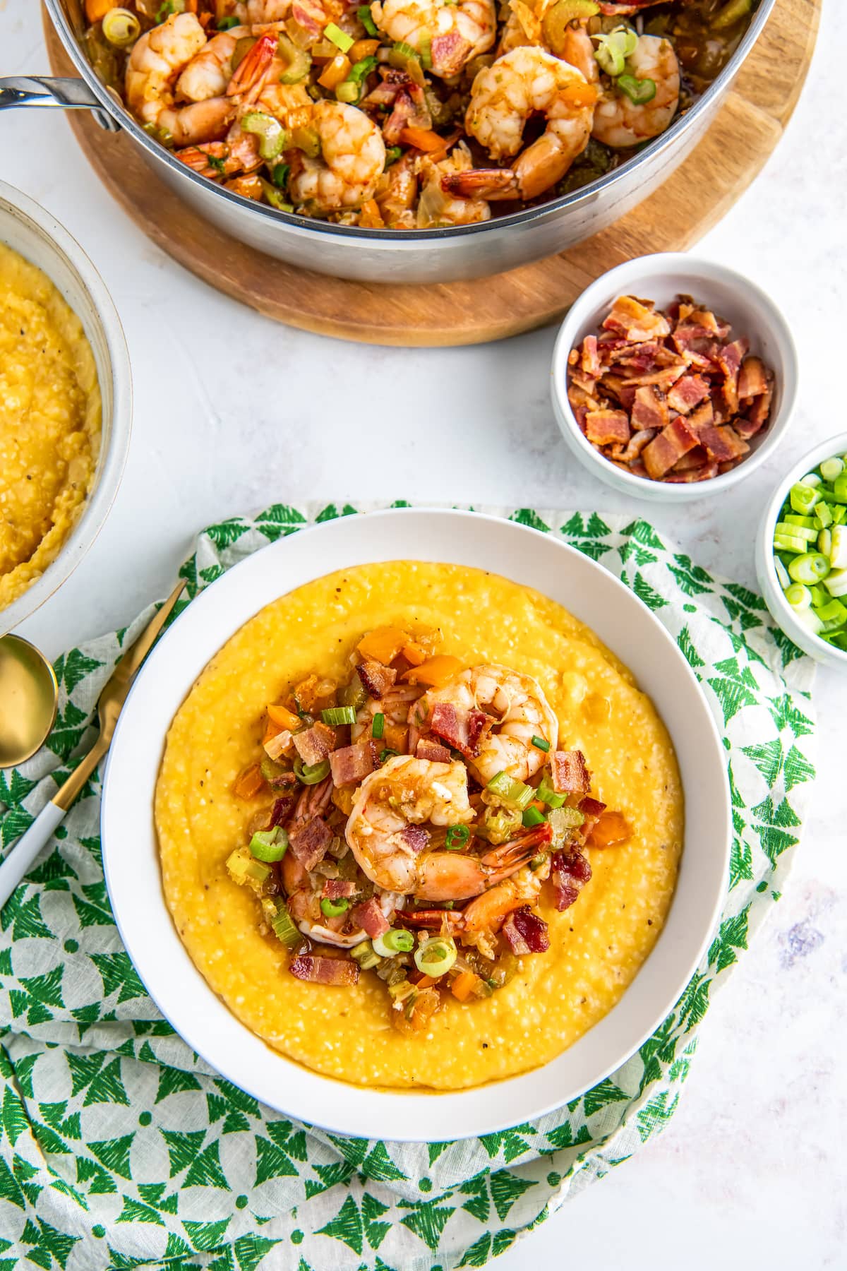 a bowl of shrimp and grits on a green and white napkin