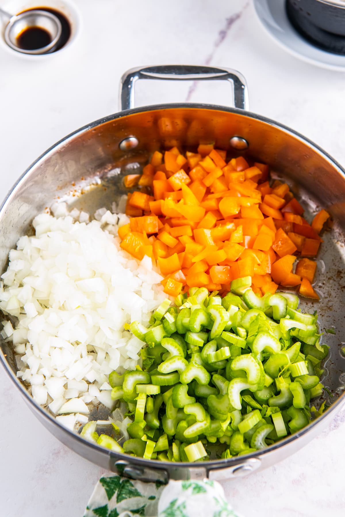 a pan with diced onion, bell peppers, and celery