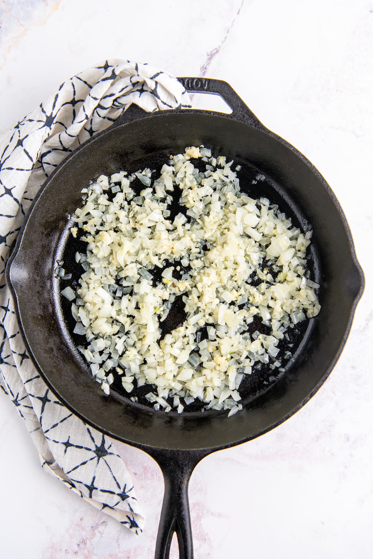 cooking minced onion in a cast iron skillet