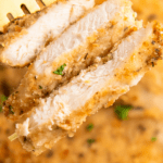 Cut crispy chicken breasts on a fork.