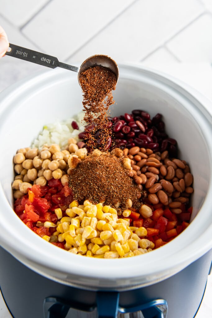Adding spices to beans for chili.