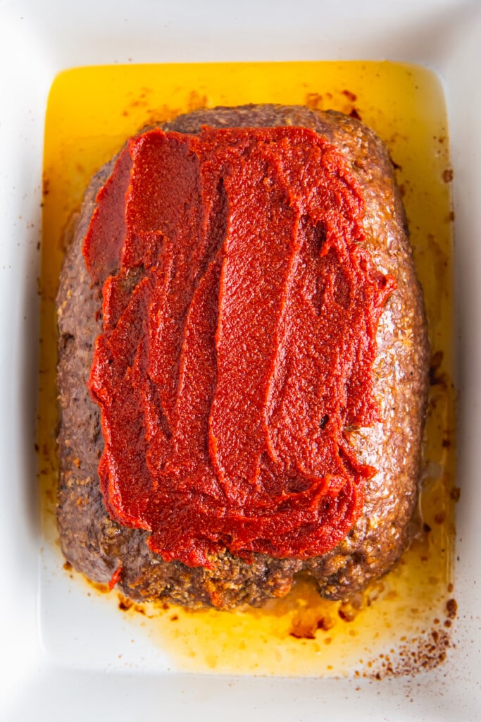 Meatloaf topped with sauce before the oven.