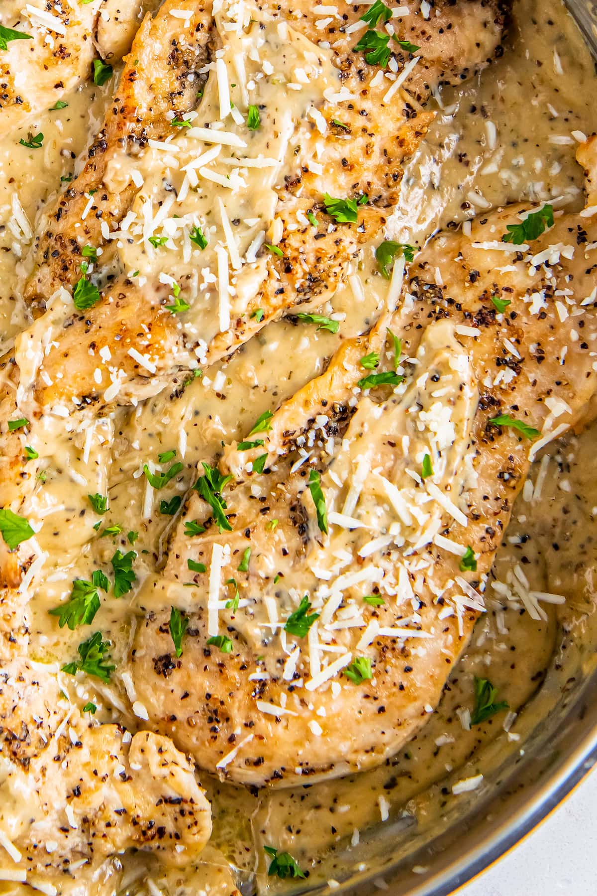 Chicken breasts are topped with cheese and fresh herbs.