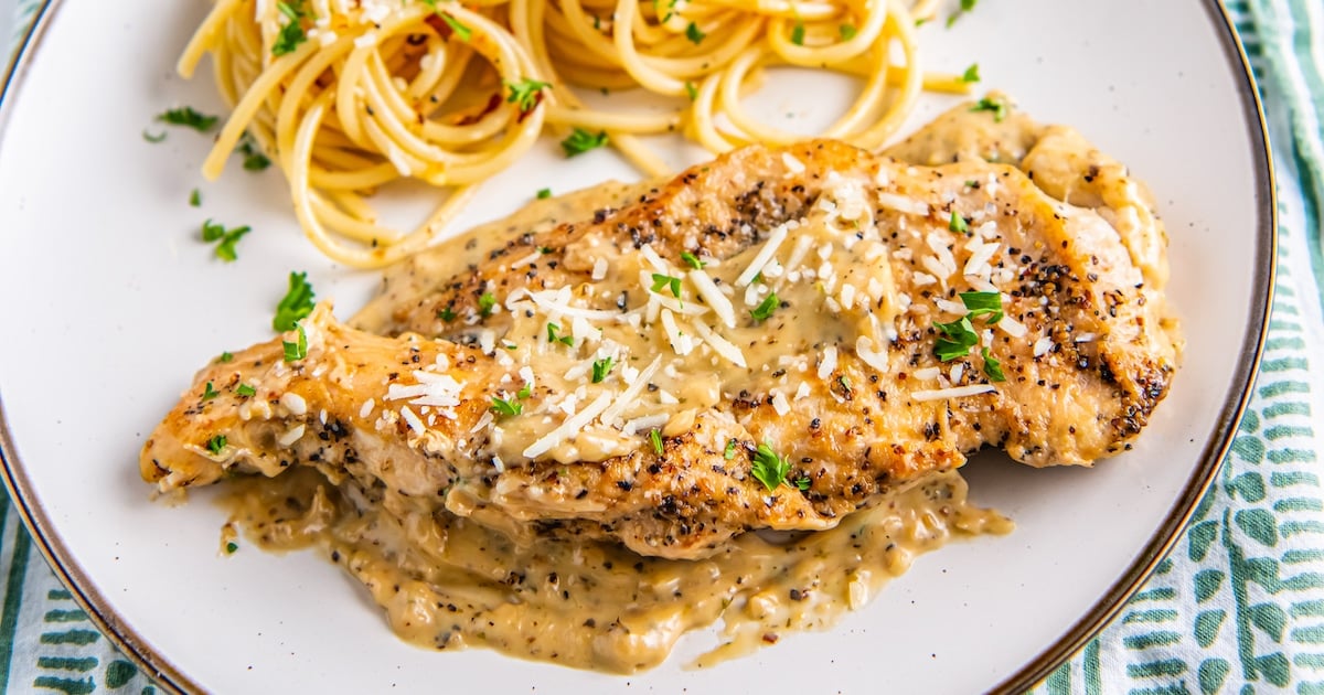 A plate of garlic chicken parmesan and spaghetti.