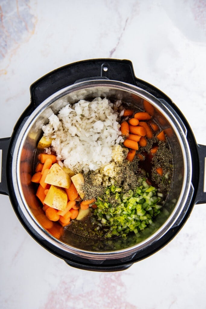 The ingredients for instant pot beef stew are added to an instant pot.