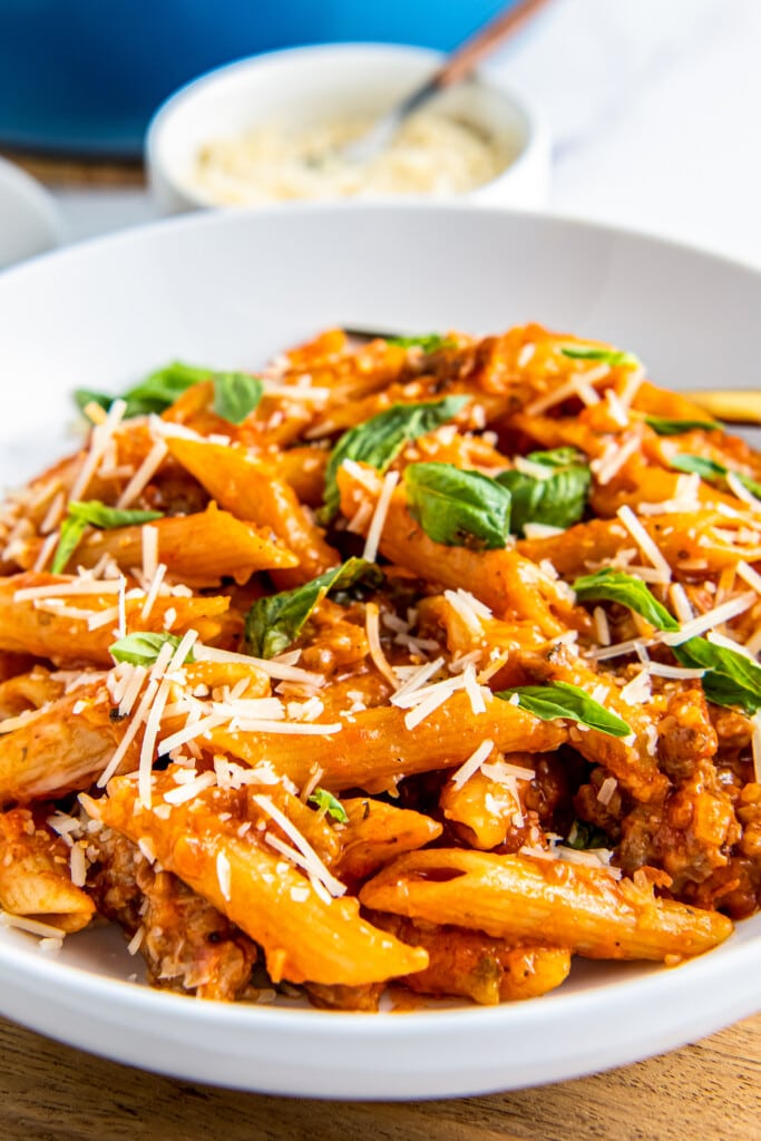 A close-up shot of One Pot Italian Sausage Pasta with cheese and basil.