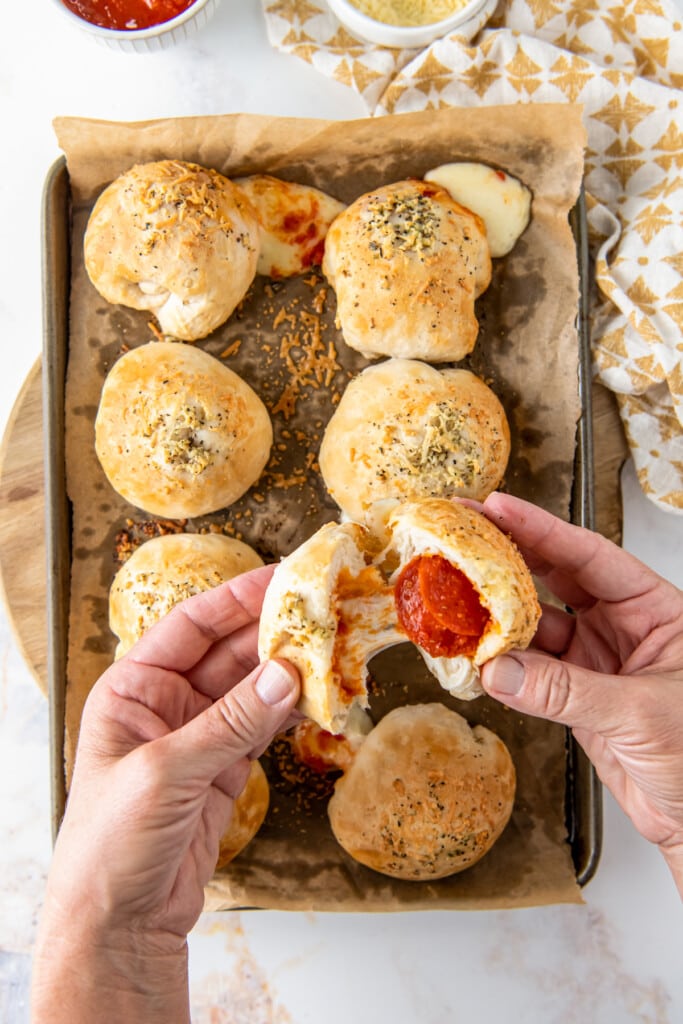 Hands open a pizza bomb to show the interior.