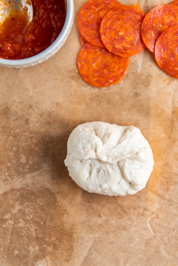 Folding up the dough to make a pizza bomb.