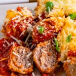 Baked meatballs cut in half on a plate.