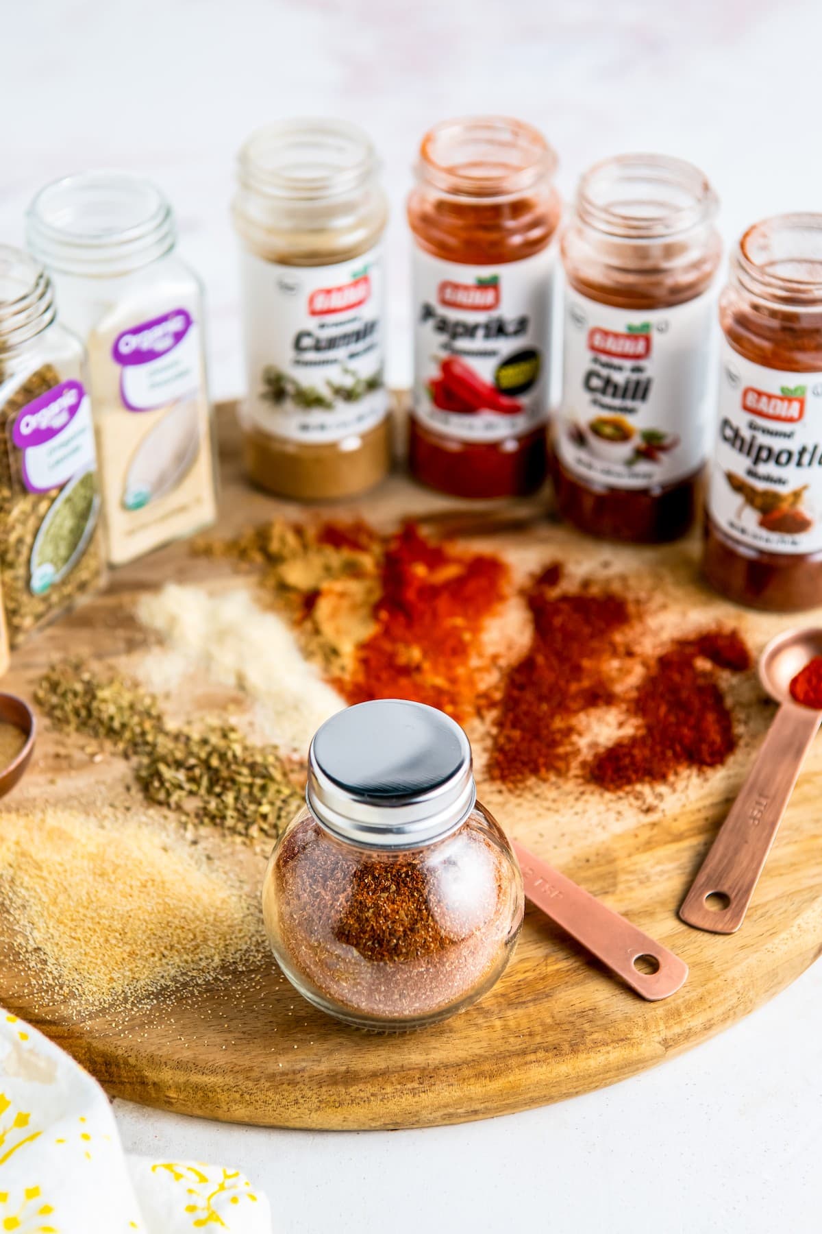 Taco seasoning in a jar, alongside the spice jars used.