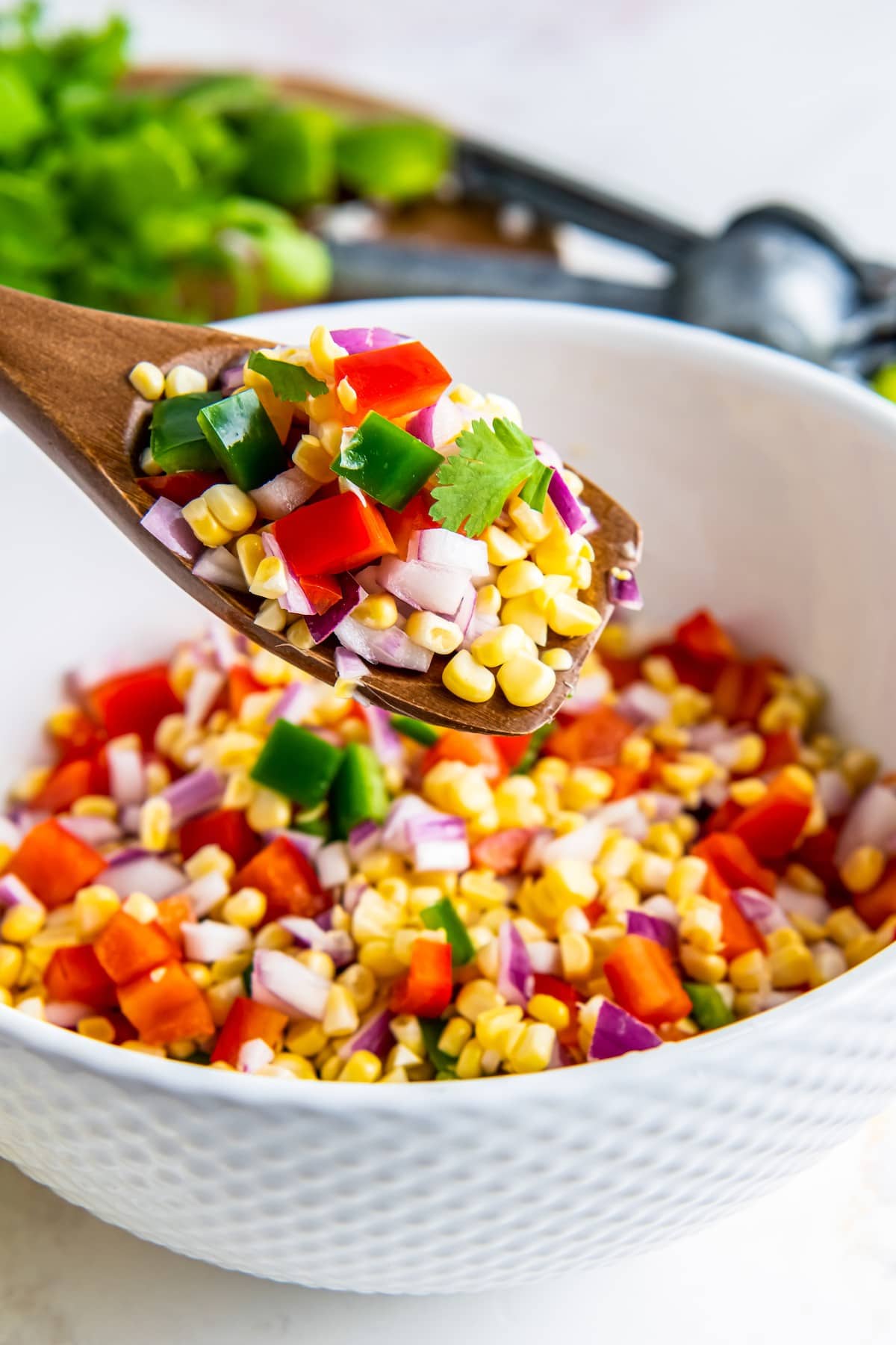 Spoonful of corn salsa with jalapeno pepper.