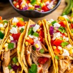 Chicken tacos topped with corn salsa and cheese.