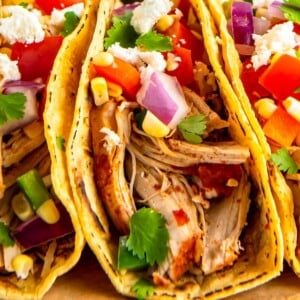 Tortillas filled with shredded chicken and corn salsa.
