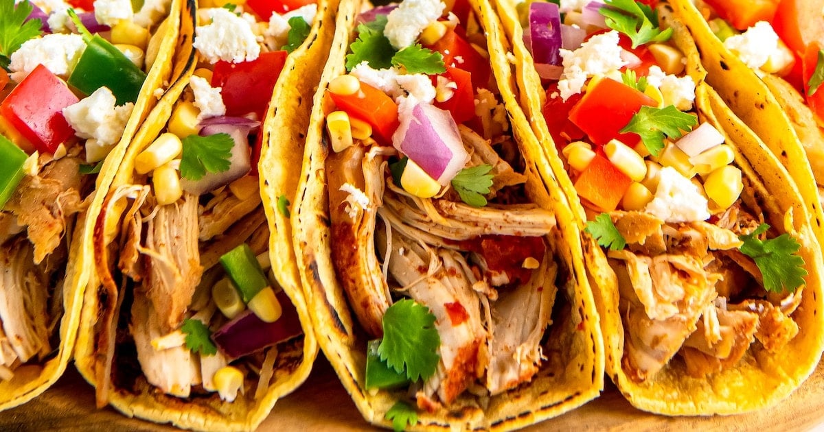 Tortillas filled with shredded chicken and corn salsa.