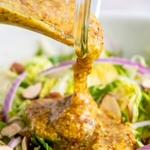 Homemade dijon mustard dressing poured over a brussels sprouts salad.