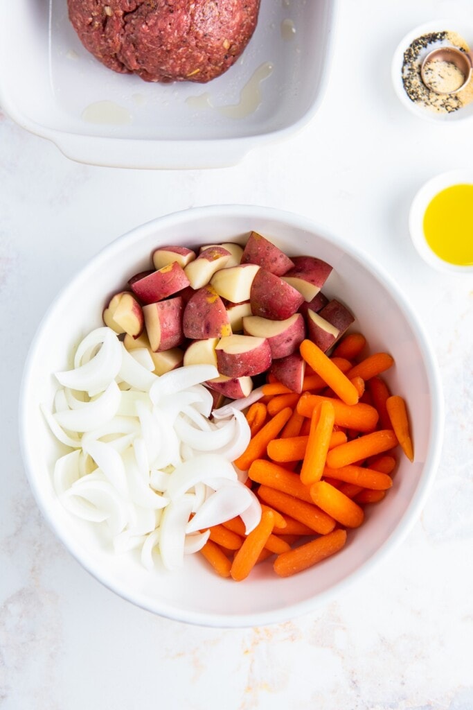 Chopped potatoes, carrots, and onion in a bowl.