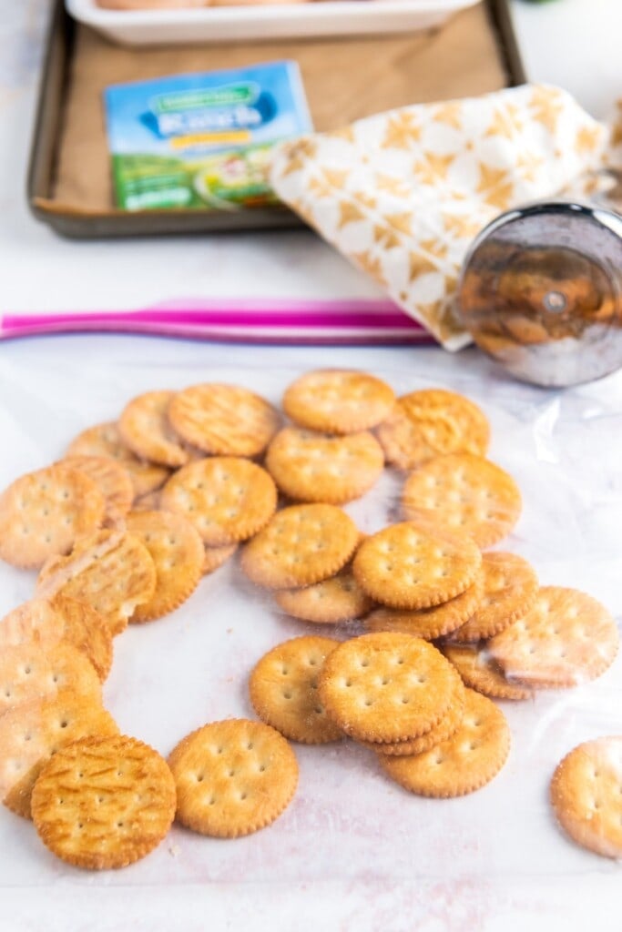 Whole ritz crackers on parchment paper.