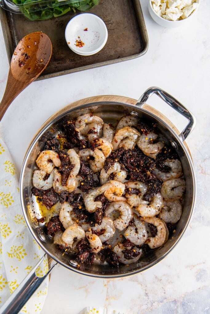 Shrimp cooking with sun-dried tomatoes.