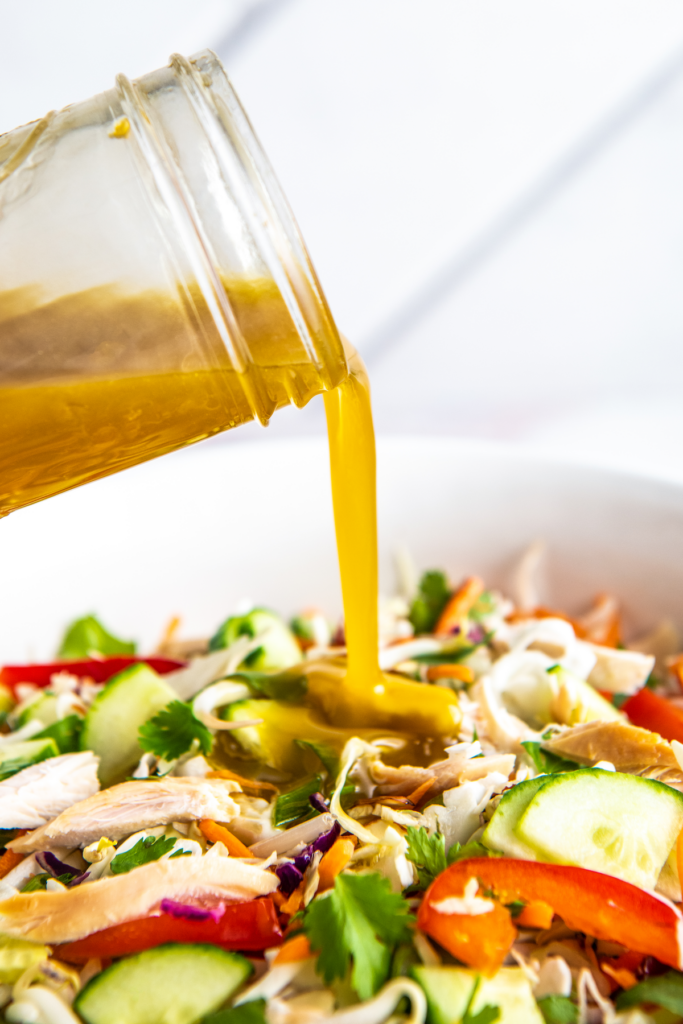 Salad dressing poured over a chopped chicken salad.