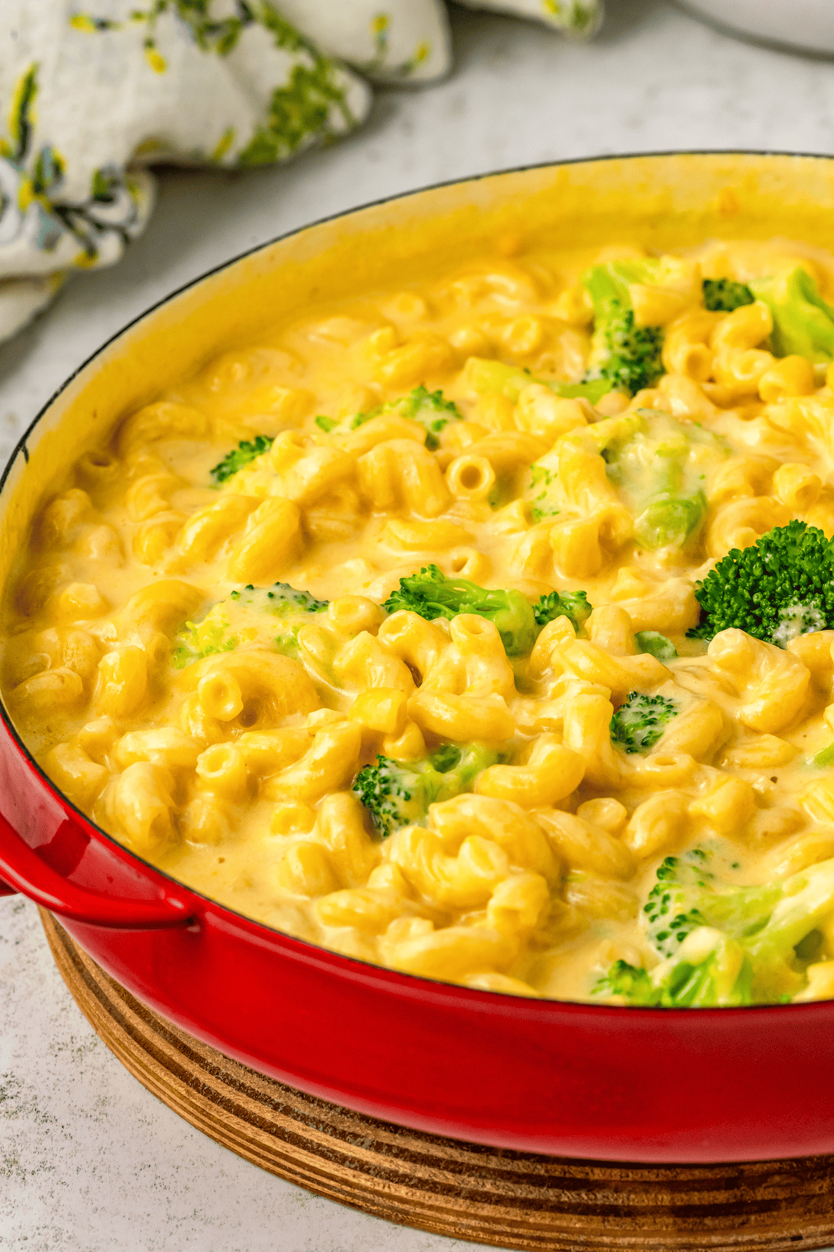 Creamy mac and cheese with pieces of broccoli in it.