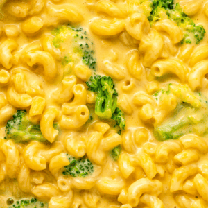 Cheddar mac and cheese with pieces of broccoli.