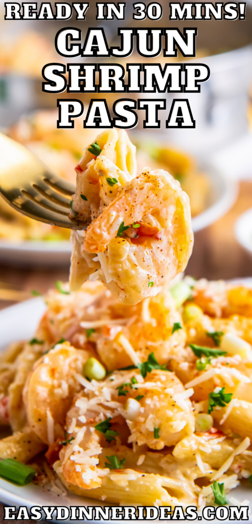 A bite of cajun shrimp pasta being picked up off of a plate by a fork.