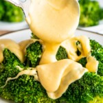 Cheese sauce poured over steamed broccoli.