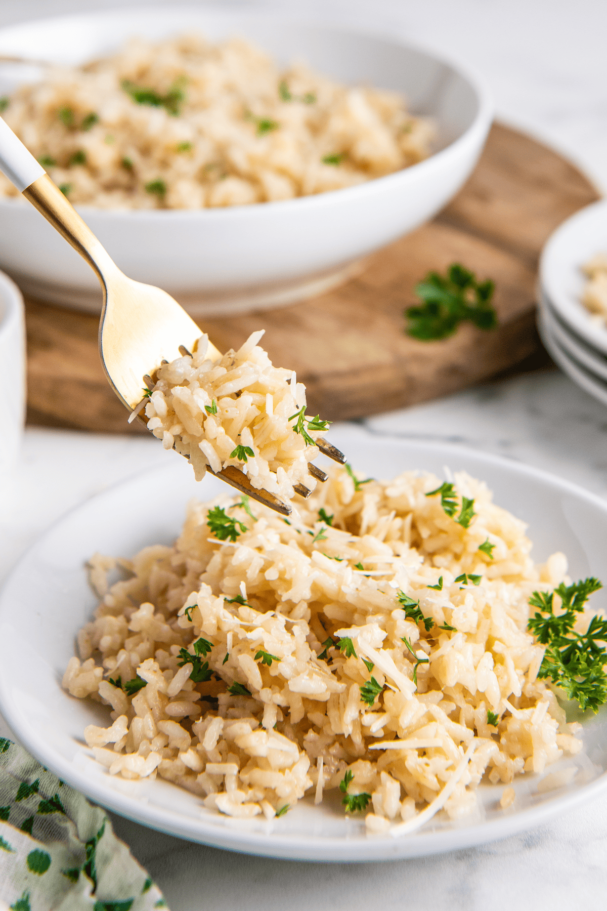 Forkful of fluffy rice topped with parmesan cheese and parsley.