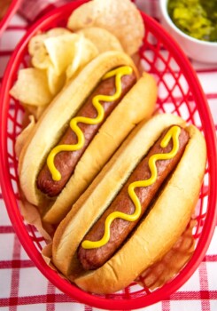 Hot dogs in buns with a squirt of mustard.