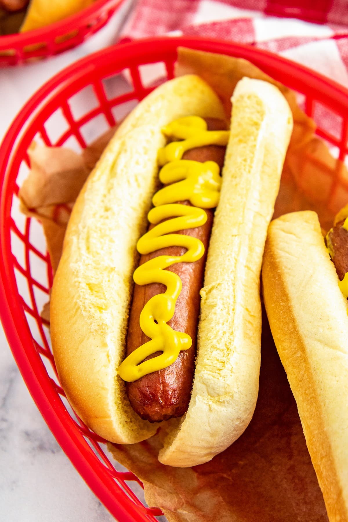 A hot dog in a bun with mustard on it.
