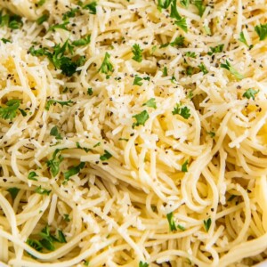 A bowl of Parmesan Butter Noodles with fresh parsley and cheese on top.