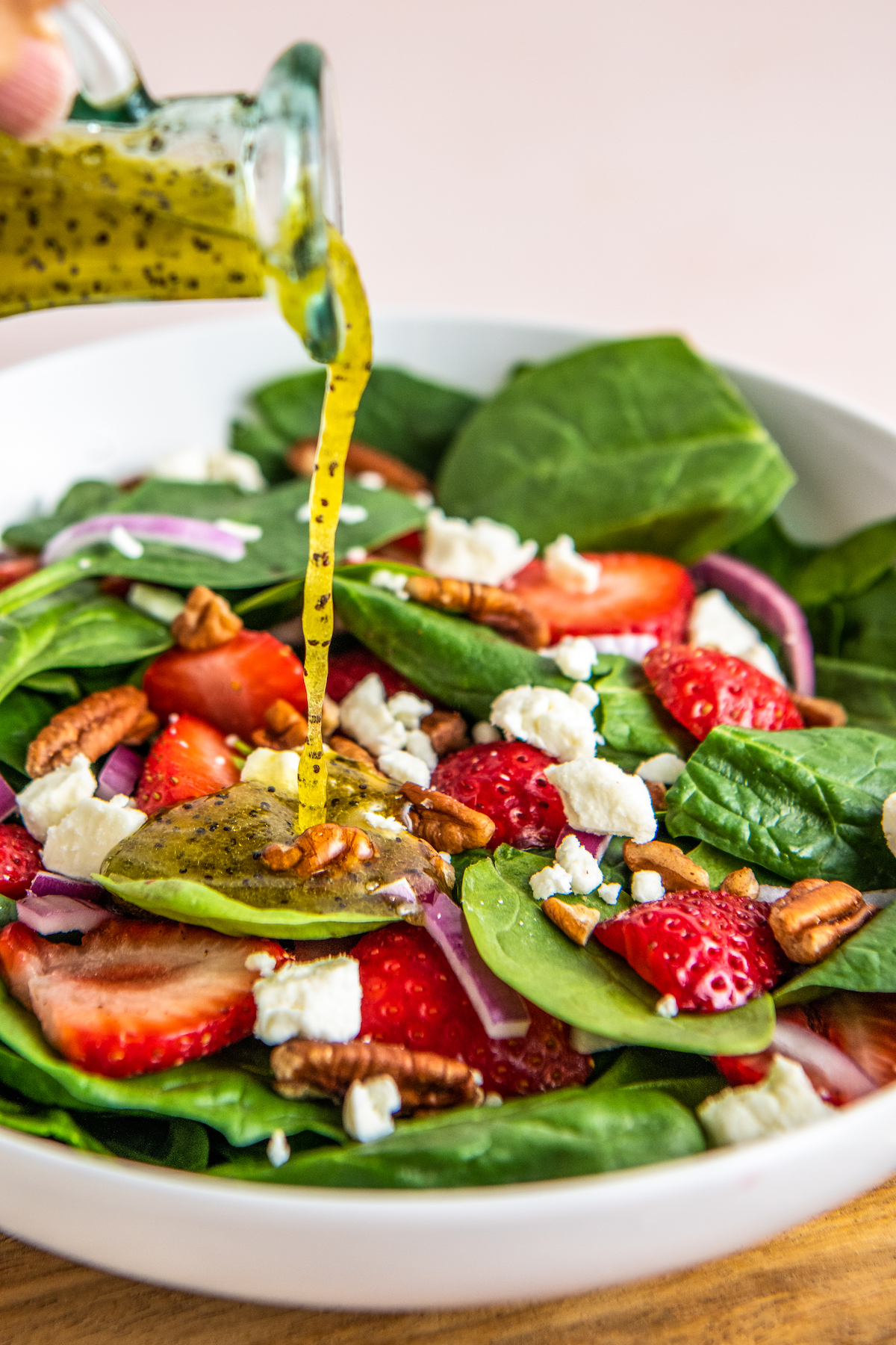 Poppy seed dressing poured over strawberry salad.