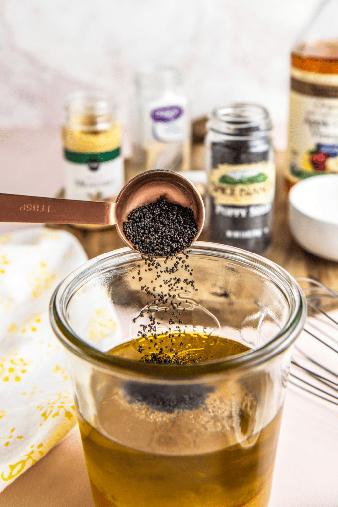 Poppy seeds poured into a jar with olive oil in it.
