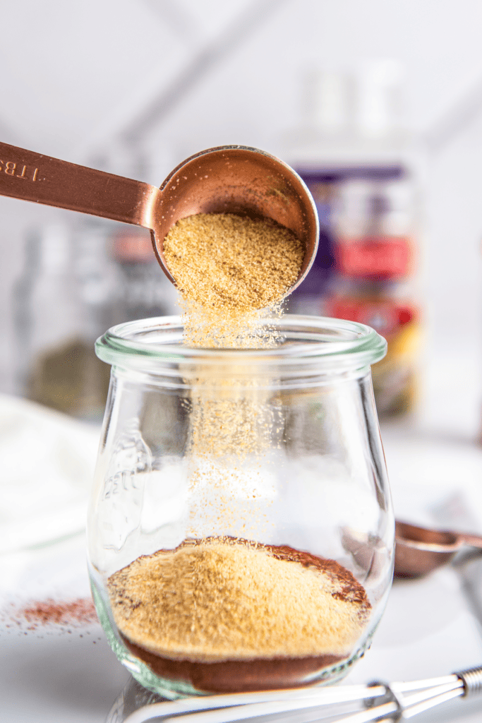 Onion powder poured into a glass jar.