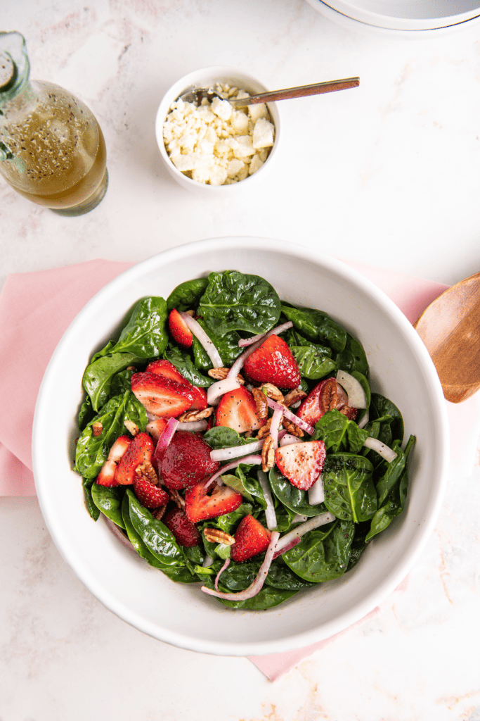Strawberries, spinach, and chopped pecans mixed together.
