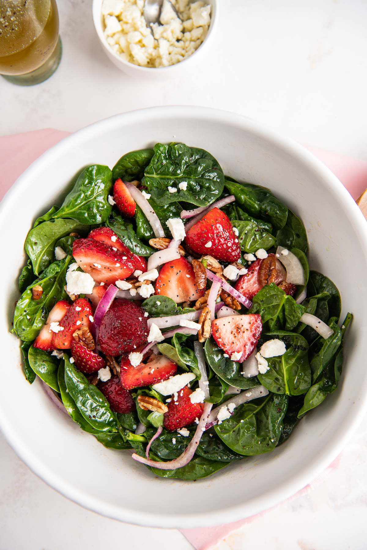 Spinach and strawberry salad topped with feta cheese.
