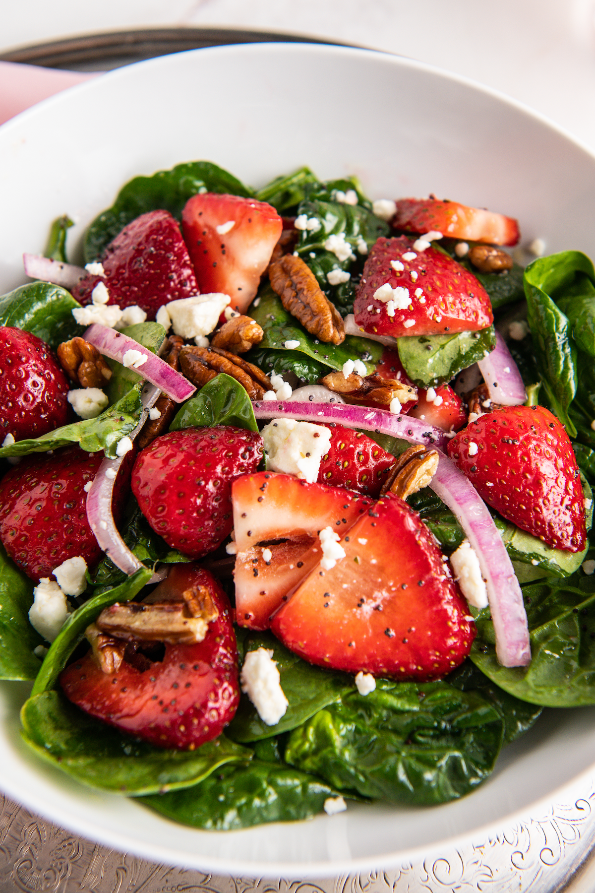 Spinach salad with strawberries, red onion, and feta cheese.