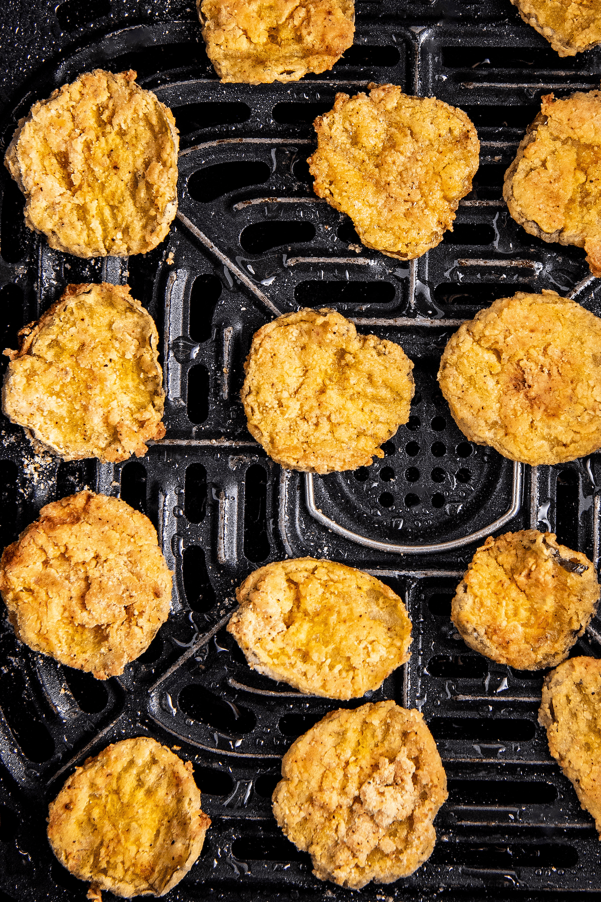 Close up overhead view of fried pickles in an air fryer basket