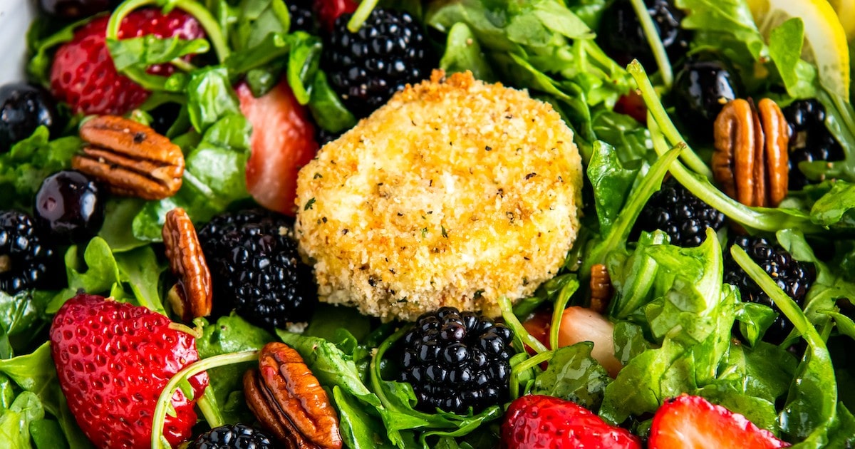 Air fryer fried goat cheese medallion on top of an arugula salad.