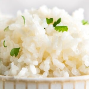 Close up of a bowl of coconut rice topped with cilantro